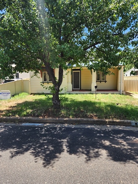 A front lawn and verge mown beside a street at a weatherboard house